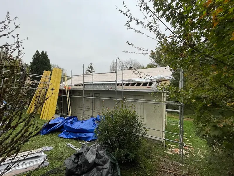 Maison sous échafaudage pendant la dépose de l'ancienne couverture