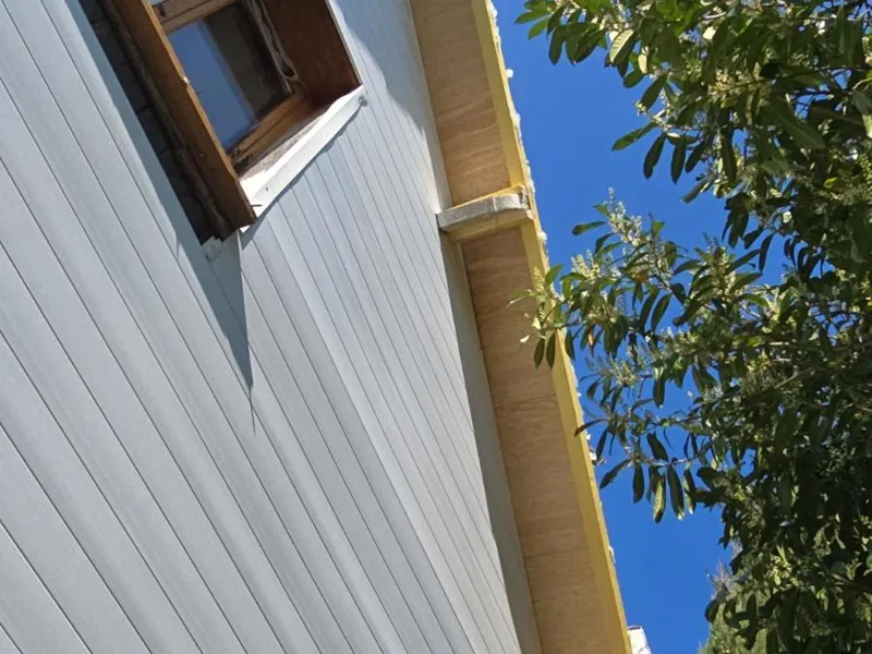 Avant-toit avec planches de rive neuves sous un ciel bleu