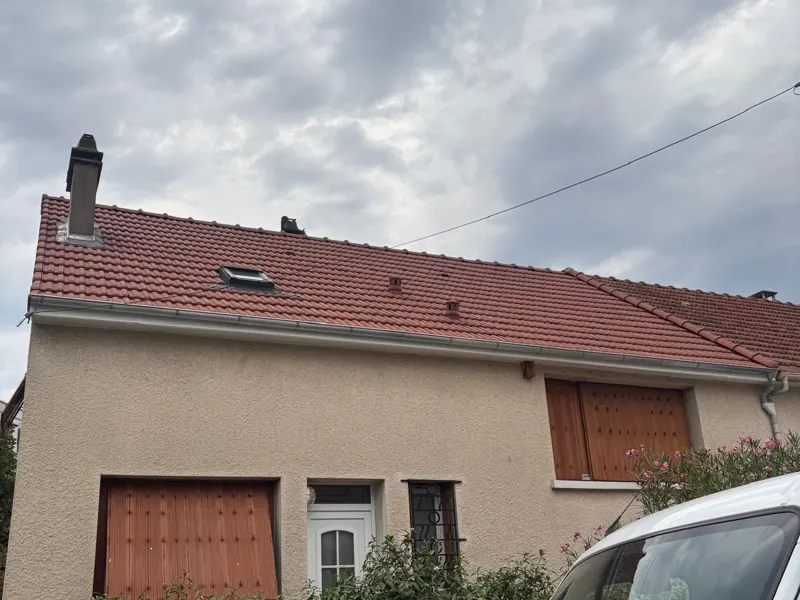 Maison avec toiture en tuiles rouges et fenêtre de toit